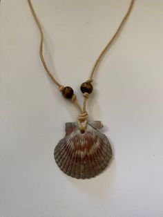 Handmade sea shell necklace crafted with a scallop shell, hemp cord, and wooden beads. Homemade Shell Necklace, Scallop Shell Necklace, Hawaiian Shell Jewelry, Sea Shells Necklace, Handmade Shell Necklace, Beaded Shell Necklace, Sea Shell Necklace Diy, Cord Necklace Diy, Diy Seashell Jewelry