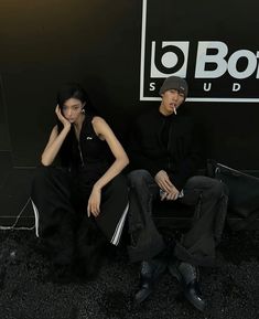 two people sitting next to each other in front of a black wall with the words bonsai studio on it