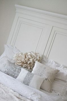 a white bed topped with lots of pillows