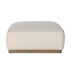 the footstool is made from white wool and has a wooden frame on it