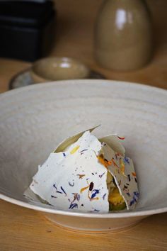 a white bowl filled with food on top of a wooden table