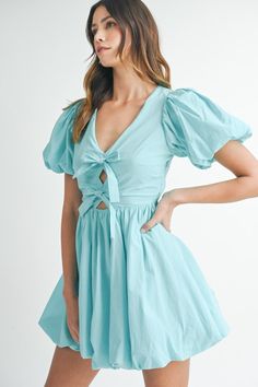 Get ready for a day of fun in our Brunch 'N' Bows dress! This poplin mini dress features cute puff sleeves, front bows, and a playful bubble hem. Its back smocked detail keeps you comfortable and stylish. The aqua color adds a touch of whimsy. Wear with your favorite sandals, sneakers or heels for a perfect brunch look! 100% Rayon True to size Model is wearing size small Available instore + online Random Wishlist, Bows Dress, Bubble Hem Dress, Bday Dinner, College Clothes, Cutest Outfits, Rush Outfits, Recruitment Outfits, Dresses A Line