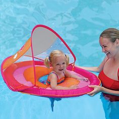 a woman and her daughter playing in the pool with an inflatable floatie