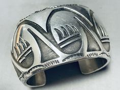 #1 Best Quality Free Returns! Vintage and Museum Quality Specialists Best Customer Service Free Shipping! Vintage and Museum Quality Click side of pic to view next picture (Click side of pic to view next picture) This is a magnificent vintage Navajo hand carved silver cuff bracelet. This fascinating bracelet consists of deep carvings that include geometric patterns and paw patterns. The detailing of the carvings on the bracelet is just astonishing. Bordering the edges of the very thick and sturdy wide silver cuff are outstanding silver wave works and sun stampings. The width of the bracelet measures around 1-1/2". Sterling silver. Cir. Mid century. The inside end to end measures around 5-1/4" with an additional 1-1/4" gap. Sturdy 97 grams. -FREE            Lifetime Warranty -FREE Medicine Pouch, Paw Pattern, Vintage Navajo, Silver Cuff Bracelet, Sterling Silver Bracelet, Silver Cuff, Geometric Patterns, Sterling Silver Bracelets, Cuff Bracelet