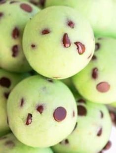 a pile of green donuts with chocolate chips on them