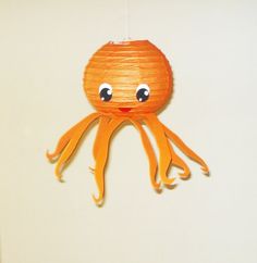 a paper lantern shaped like an octopus hanging from a string with eyes on it's head