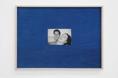 a blue photo frame with a man and woman in the middle, hanging on a wall