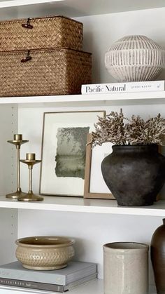 the shelves are filled with vases, pictures and other decorative items such as baskets