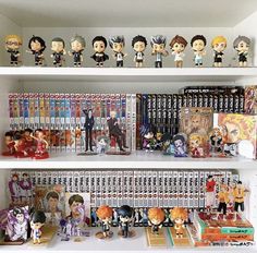 a shelf filled with lots of anime figurines on top of white shelving