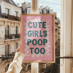 a person holding up a sign that says cute girls poop too in front of a window