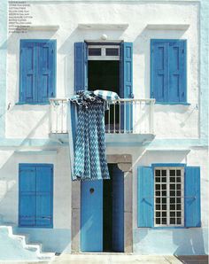 a blue and white house with shutters open