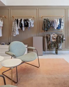 a room filled with lots of clothes on hangers next to a white counter top