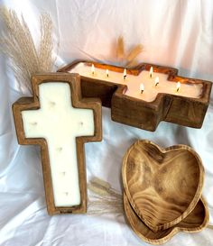 two wooden crosses and a heart shaped box with candles in it on a white background