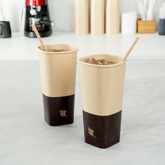 two cups with straws in them sitting on a counter