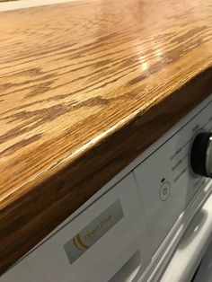 a wooden counter top next to a washer and dryer