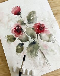 a watercolor painting of red roses on a white paper with a black ink brush