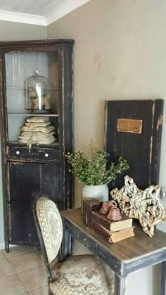 an old desk and chair in a room with tile flooring, bookshelf and cabinet