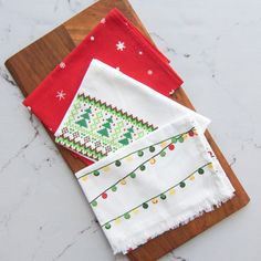 three christmas napkins on a cutting board