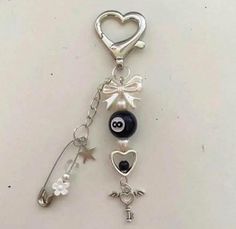 a keychain with a heart, eyeball and keys attached to it on a white surface