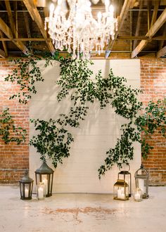 an indoor area with candles and greenery on the wall