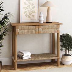 a wooden table with two drawers and a lamp on top of it next to a potted plant