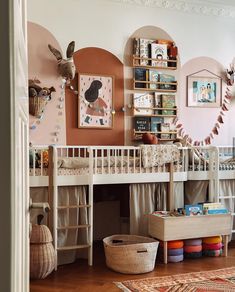 there is a white bunk bed in the room with pink walls and wooden flooring