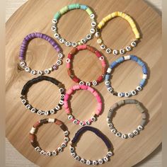 a bunch of bracelets that are sitting on a wooden table with the word love spelled in small letters