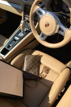 the interior of a luxury car with an electronic device and purse on the dash board