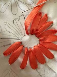 an orange flower is being stitched onto the fabric