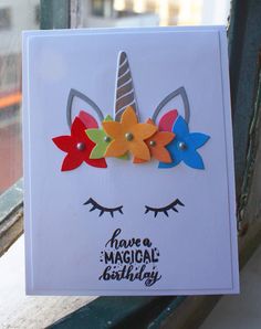 a card with an image of a unicorn's face and colorful flowers on it