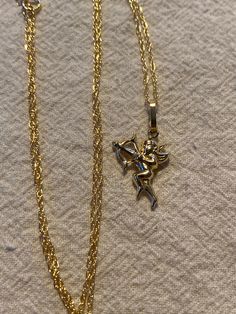 Cupid pendant in 14kt yellow gold. Measures about 1" including bail. Hangs from an 18" gold filled chain . Love the Cupid with his arrow! Weighs .81 gms. Vintage never worn brand new Formal Gold Charm Necklace, Valentine's Day 14k Gold Hallmarked Jewelry, Collectible Gold Heart Pendant Jewelry, Antique Yellow Gold Necklaces For Valentine's Day, Gold Jewelry For Valentine's Day Collectible, Formal 14k Gold Pendant Charm Necklace, Vintage Yellow Gold-plated Charm Necklaces, Gold Heart Pendant Large Jewelry, Fine Jewelry 14k Stamped Pendant Charm Necklace