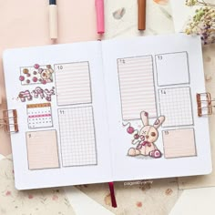 an open planner book with stickers on it next to some pens and pencils