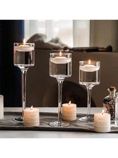 candles and wine glasses on a tray in front of a window with the words boss written on it