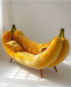 a banana shaped chair sitting on top of a white floor in front of a window