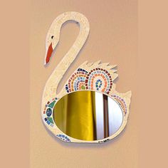 a white swan shaped mirror mounted to the side of a wall