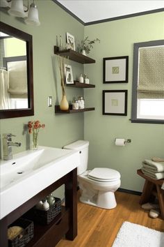 a bathroom with green walls and white fixtures