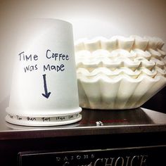 a coffee cup sitting on top of a microwave oven next to a paper mache