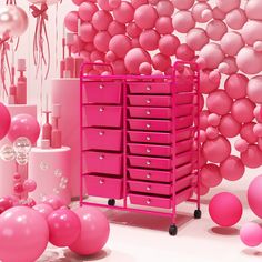 a pink room filled with lots of balloons