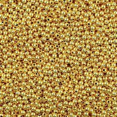 gold colored beads are shown in this close up shot, with the background texture visible