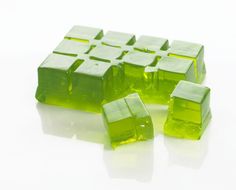 green cubes sitting on top of each other in the middle of a white surface