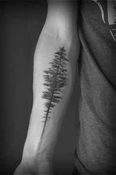 a man's arm with a tree tattoo on the left side of his arm