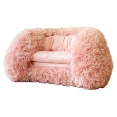 a pink dog bed with fluffy fur on the top and bottom, in front of a white background