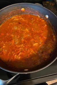 a pot filled with soup sitting on top of a stove