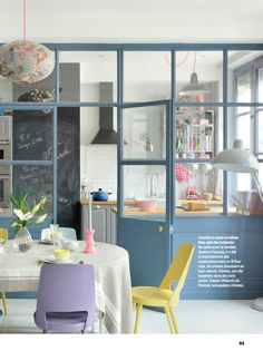 an image of a kitchen setting with chairs and table in the foreground, chalkboard on the back wall