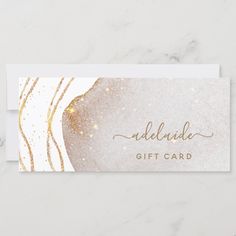 a white and gold gift card with glitter