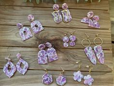 several pieces of pink and white marbled jewelry laid out on a wooden table next to plants