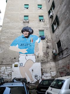 a mural on the side of a building depicting a man in blue jersey and white shorts