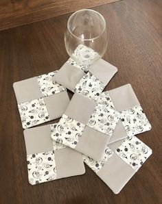 a wine glass sitting on top of a wooden table next to coasters with mickey mouse designs