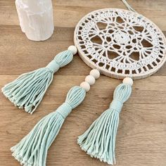 two tassels and a beaded dream catcher on a wooden table