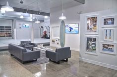 a living room with couches and pictures on the wall in it's center